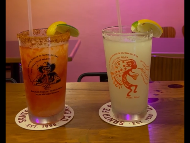 Two margaritas in branded Taos Pizza Out Back and Smoke Shack pint glasses on the bar