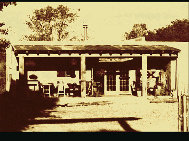 Sepia-toned historic photo of the original Out Back adobe building and its covered porch