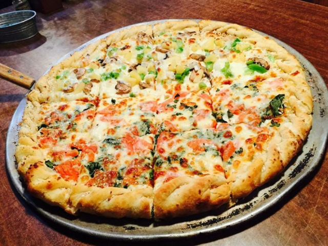 Half veggie, half tomato-basil pizza on a well-seasoned pan
