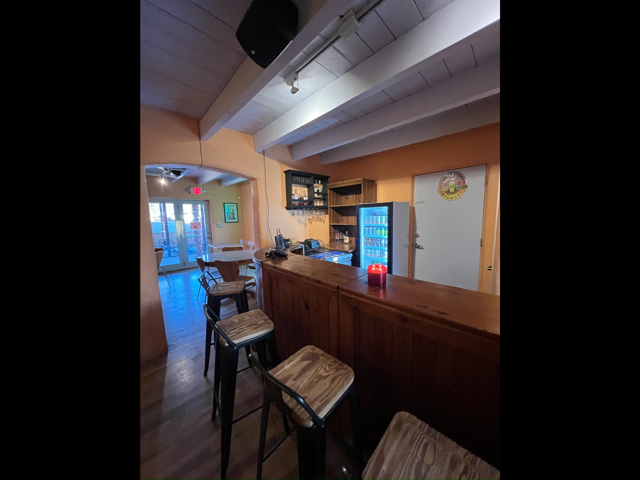 Wood bar with stools, cooler and beamed ceiling inside the Outback Bar