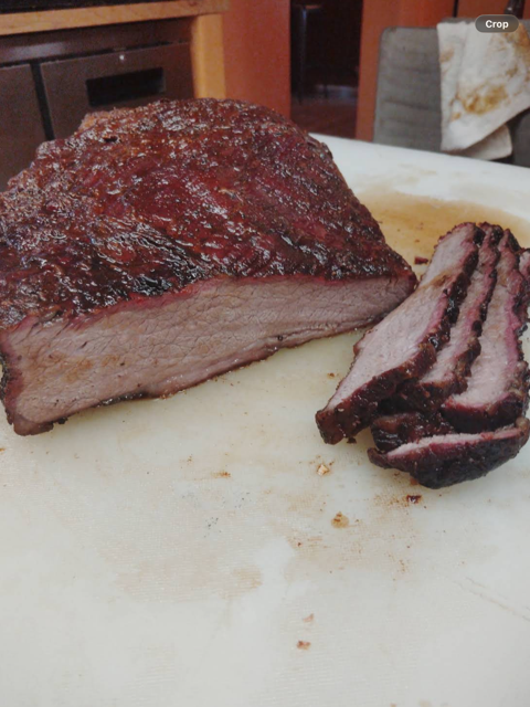 Smoked brisket with a deep bark, sliced to show the smoke ring
